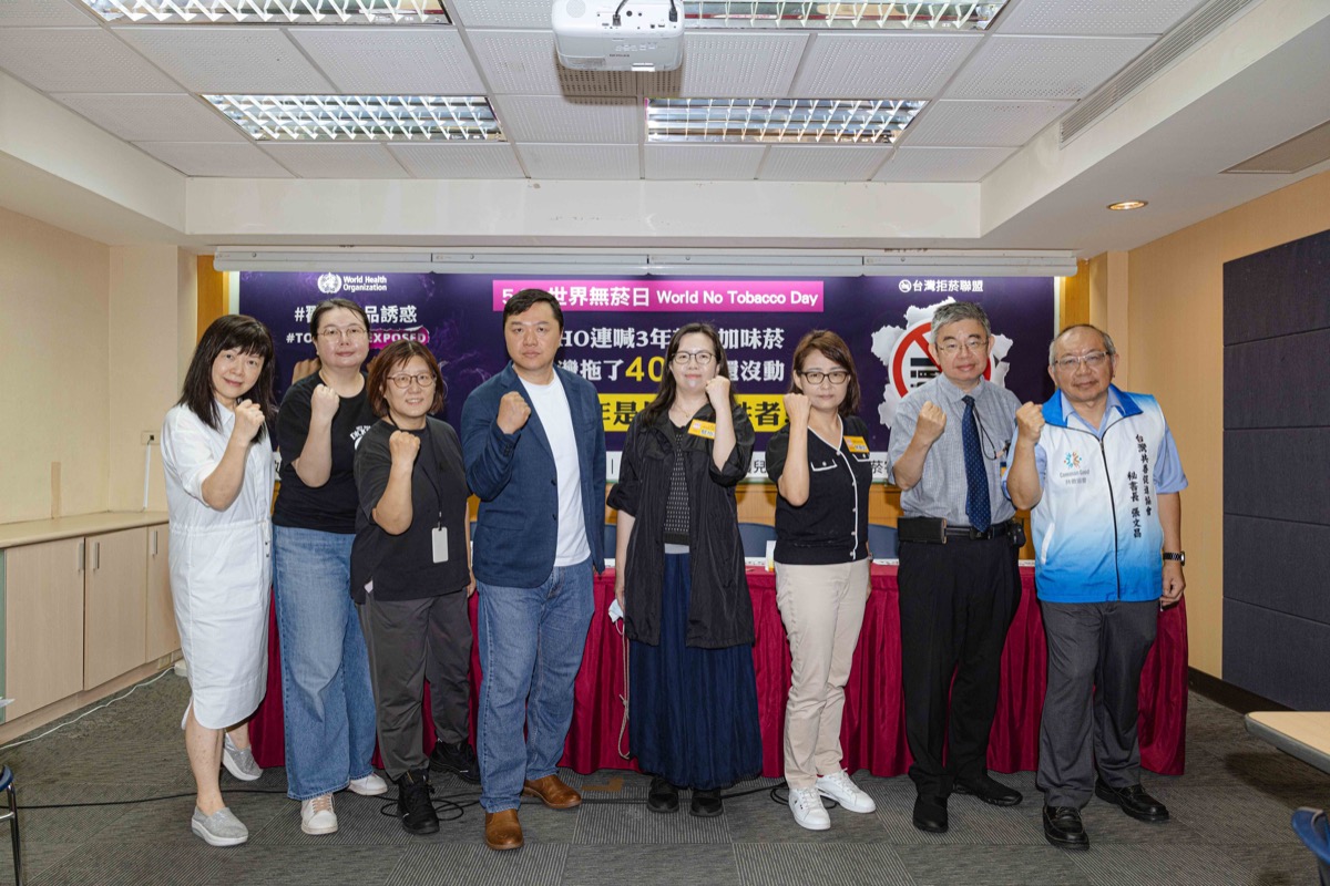 台灣拒菸聯盟世界無菸日記者會，國教行動聯盟等 6 個民間團體代表於『WHO 連喊 3 年禁止加味菸』背板前合影舉拳